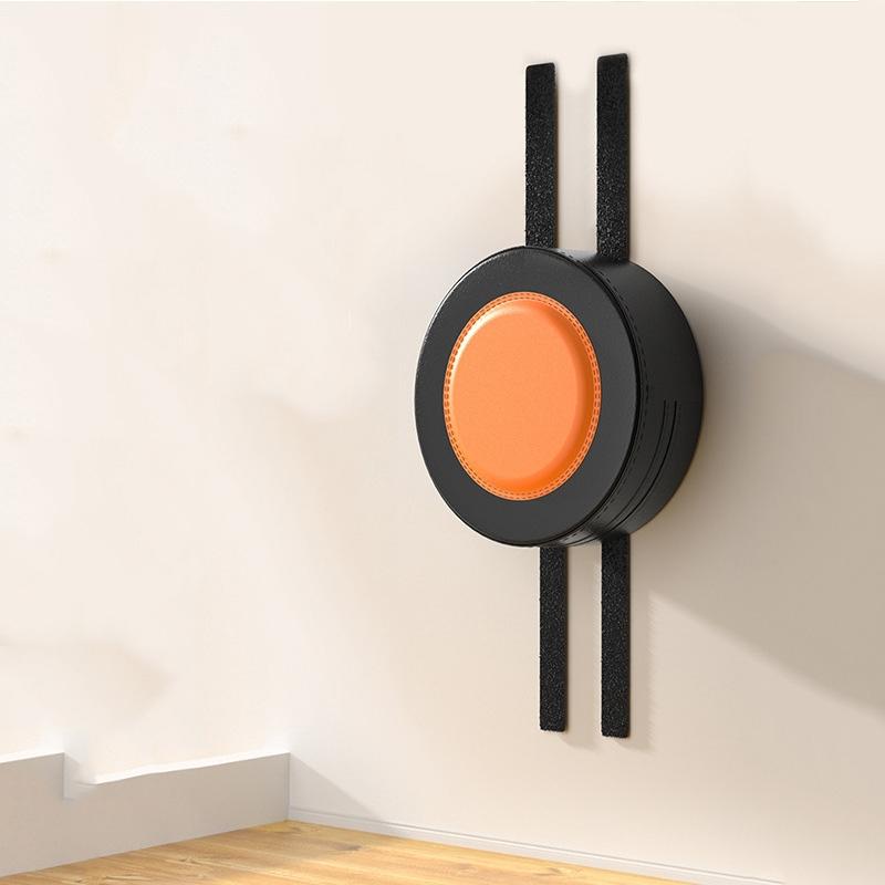 Modern wall-mounted light fixture with orange center and black exterior on a neutral wall.