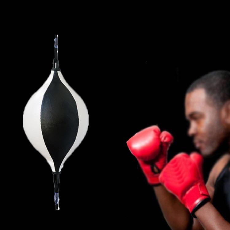 Boxer in red gloves preparing to strike a black and white speed bag against a black background