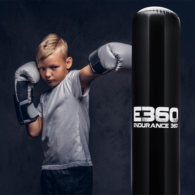 Child in boxing gloves posing next to a punching bag with 'E360 Endurance 360' branding.