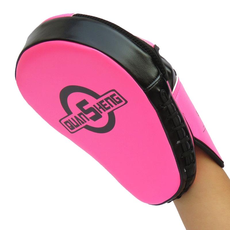 Pink and black martial arts training pad held by a person on a white background