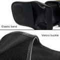 Close-up of a black leather bag with an elastic band and velcro buckle on a white background.